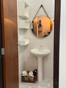 a bathroom with a sink and a mirror at Apart Aconchego Mobiliado até 4 pessoas Centro in Sinop