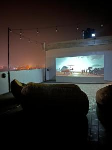 Zimmer mit einem großen Bildschirm mit einem Film in der Unterkunft Ivy Residence 4br 6ba with terrasse in Porto-Novo