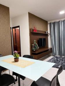 - un salon avec une table et des chaises blanches dans l'établissement Apartamento em Araguari, à Araguari