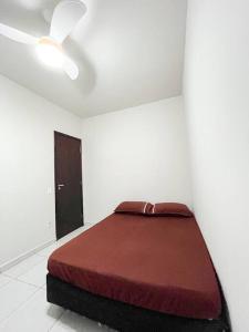 Ce lit se trouve dans un dortoir blanc doté d'un ventilateur de plafond. dans l'établissement Apartamento em Araguari, à Araguari