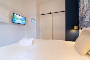 una camera con letto bianco e TV a parete di Equipped studio in the center of Lille a Lille