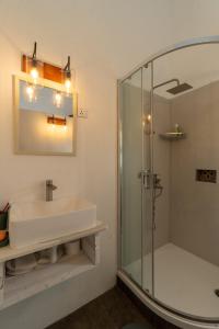 a bathroom with a glass shower and a sink at El-Sangha Studio 2mina pieds de la plage de baie du cap in Baie du Cap