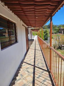 uma varanda com uma pérgula de madeira numa casa em Departamento em San Miguel