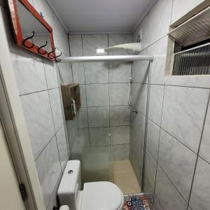 La salle de bains est pourvue d'une douche et de toilettes. dans l'établissement Kitnet em Torres, à Torres