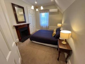 a bedroom with a bed and a table with a lamp at Porters Cottage Oasis in Albury