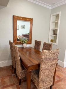 a dining room table with chairs and a mirror at Porters Cottage Oasis in Albury