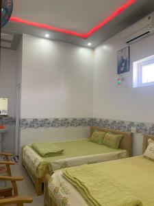een kamer met 2 bedden en een rood plafond bij Nhà nghỉ Bá Thành - Lý Sơn in Quang Ngai