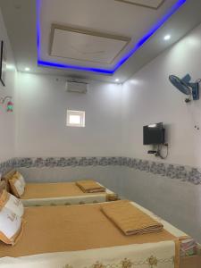 Zimmer mit 3 Betten und blauem Licht in der Unterkunft Nhà nghỉ Bá Thành - Lý Sơn in Quảng Ngãi