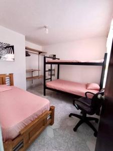 a room with two bunk beds and a chair at Casa familiar cerca a la estación del metro in Medellín