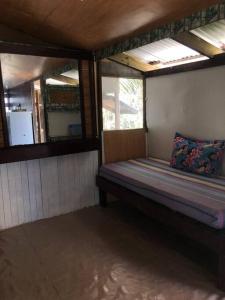 a small room with a bed and a window at FARE Tatahi in Parea