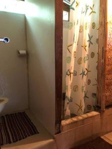 a shower in a bathroom with a shower curtain with butterflies at FARE Tatahi in Parea