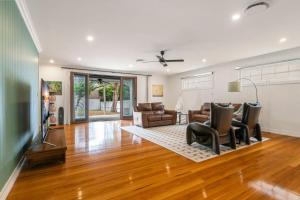 uma sala de estar com uma televisão e um sofá em Unique Character Queenslander Home! Just Minutes to CBD & South Brisbane em Brisbane