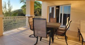 patio con mesa y sillas en el balcón en Gated waterfront condo with boat dock and view, en Freeport