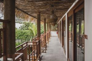 a hallway with tables and chairs in a resort at Roomates Hostel Canggu by Ini Vie Hospitality in Canggu