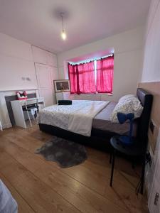 a bedroom with a bed and a red window at Esther's Peaceful Oasis in Erith