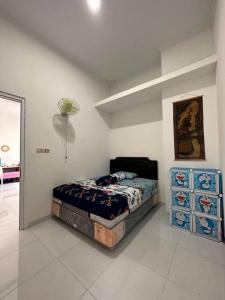 Mahardika Homestay Gamping في سليمان: غرفة نوم بها سرير وكلب مستلقٍ عليه