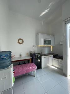 Mahardika Homestay Gamping في سليمان: مطبخ مع كرسي وردي في الغرفة