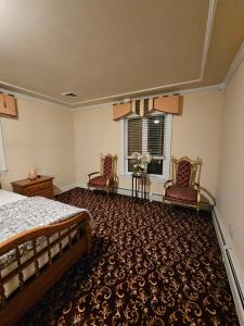 1 dormitorio con 2 sillas, 1 cama y 1 ventana en A cozy shared house with a friendly vibe, en Metuchen