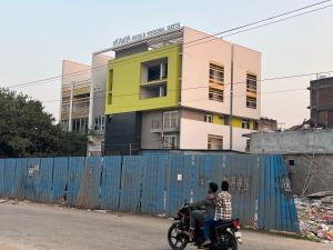 two people riding a motorcycle in front of a building at nKAaSA hotel Personal Suites in Raxaul