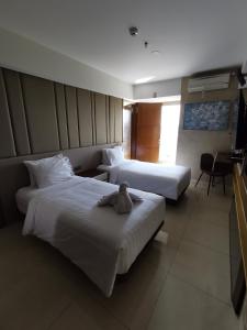 スマランにあるWarhol Residence Semarang Simpang Limaのベッド2台(テディベア付)