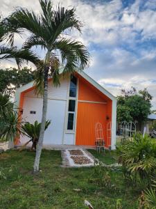 una casa blanca y naranja con una palmera en คุณเก้า รีสอร์ท, 