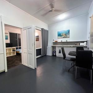 ein Wohnzimmer mit einem Tisch und Stühlen im Zimmer in der Unterkunft Unit 2 Golden Sands Retreat in Wagait Beach