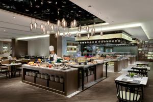 a chef is preparing food in a restaurant at Courtyard by Marriott Changsha South in Changsha