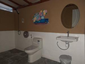 a bathroom with a toilet and a sink and a mirror at Lazy Hut in Ko Phayam
