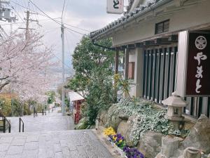 a street next to a building with flowers in front of it at Kanko Ryokan Yamato in Ikuma