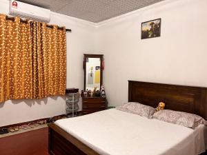 1 dormitorio con cama, tocador y espejo en Cozy village house en Tudugalla