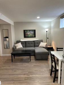 Entire Basement Guest Suite In Cranbrook في كرانبروك: غرفة معيشة مع أريكة وطاولة