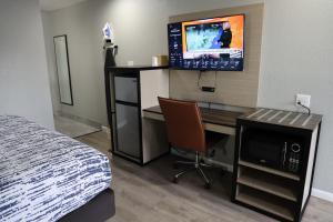 1 dormitorio con escritorio, ordenador y TV en Copper Manor Motel, en Silver City