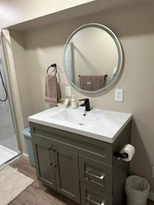 Entire Basement Guest Suite In Cranbrook في كرانبروك: حمام مع حوض ومرآة