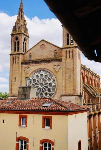 a large church with a tower and a building at La Perle des Carmes in Toulouse