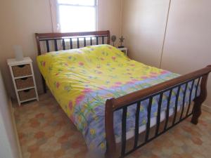 a bedroom with a bed with a colorful comforter at Bonnie Bliss - James Well in Perara