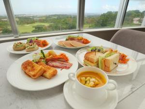 a table with plates of food and a cup of soup at ANSA Okinawa Resort in Uruma