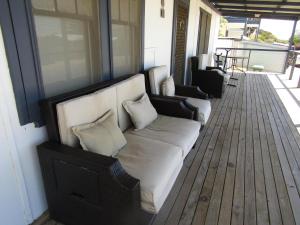 a couch sitting on a porch with pillows on it at Bonnie Bliss - James Well in Perara