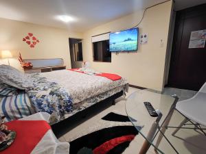 a bedroom with a bed and a glass table at TURI Suite con Jacuzzi, centro de la ciudad in Baños
