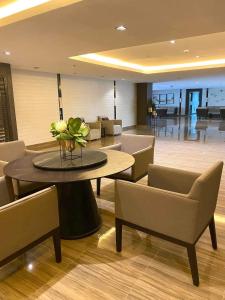 a lobby with chairs and a table with a vase of flowers at Urbanview Oasis at Air Residences in Manila