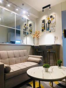 - un salon avec un canapé et une table dans l'établissement Urbanview Oasis at Air Residences, à Manille