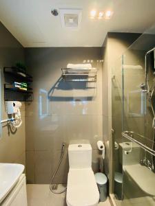 La salle de bains est pourvue de toilettes, d'une douche et d'un lavabo. dans l'établissement Urbanview Oasis at Air Residences, à Manille