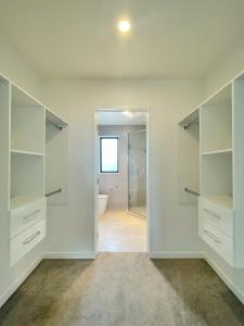 an empty bathroom with white shelves and a toilet at Your Modern Home in Sandringham, Close to City, Heat Pumps, Netflix, Parking in Auckland