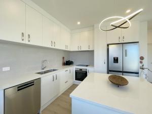 a kitchen with white cabinets and a white counter top at Your Modern Home in Sandringham, Close to City, Heat Pumps, Netflix, Parking in Auckland