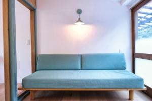 a blue couch in a room with a window at palette in Numazu