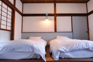 two beds sitting next to each other in a room with windows at palette in Numazu