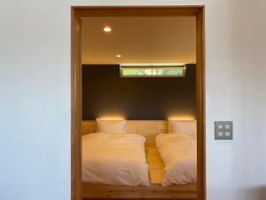 安曇野市にある北アルプス山麓の貸切サウナと貸別荘Azumino36stayのベッドルーム(鏡にベッド2台付)