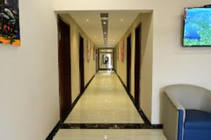 un pasillo de un edificio con un pasillo largo en The One Hotel Nashik en Nashik