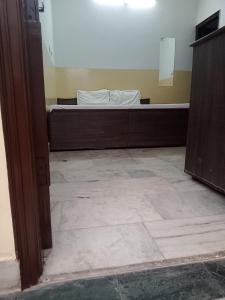 une pièce vide avec un lit dans l'angle d'une pièce dans l'établissement Om Sai palace, à Chandigarh