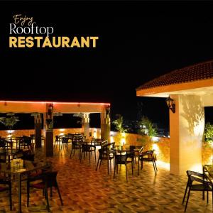 a restaurant with tables and chairs at night at Adarsha Palace Hotel in Chuknagar