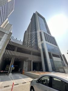 a car parked in front of a large building at OVAL TOWER in Dubai